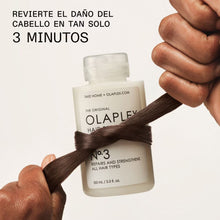 Cargar imagen en el visor de la galería, manos sosteniendo cabello y bote de olaplex N°3 100 ml