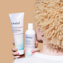 Cargar imagen en el visor de la galería, Modelo con botella de Shampoo violeta y mascarilla Ouidad Advanced Climate Control 250ml para neutralizar tonos amarillos.