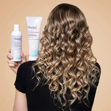 Cargar imagen en el visor de la galería, Modelo con botella de Shampoo violeta y mascarilla Ouidad Advanced Climate Control 250ml para neutralizar tonos amarillos.