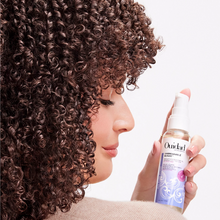 Cargar imagen en el visor de la galería, Modelo usando Aceite Ouidad Unbreakable Bonds 59ml para reparar rizos dañados.