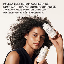 Cargar imagen en el visor de la galería, Modelo con botellas de olaplex N°5 y N°4 250 ml