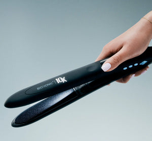 Plancha Bio Ionic Luxe 10X 1 pulgada con mano en botones