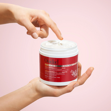 Cargar imagen en el visor de la galería, Manos agarrando Mascarilla Ouidad Advanced Climate Control 311g para nutrir y controlar el frizz.
